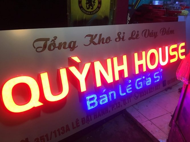 Bảng hiệu mica tích hợp đèn LED được lắp đặt phía trước cửa hàng hoặc tòa nhà, phát sáng rực rỡ trong đêm.